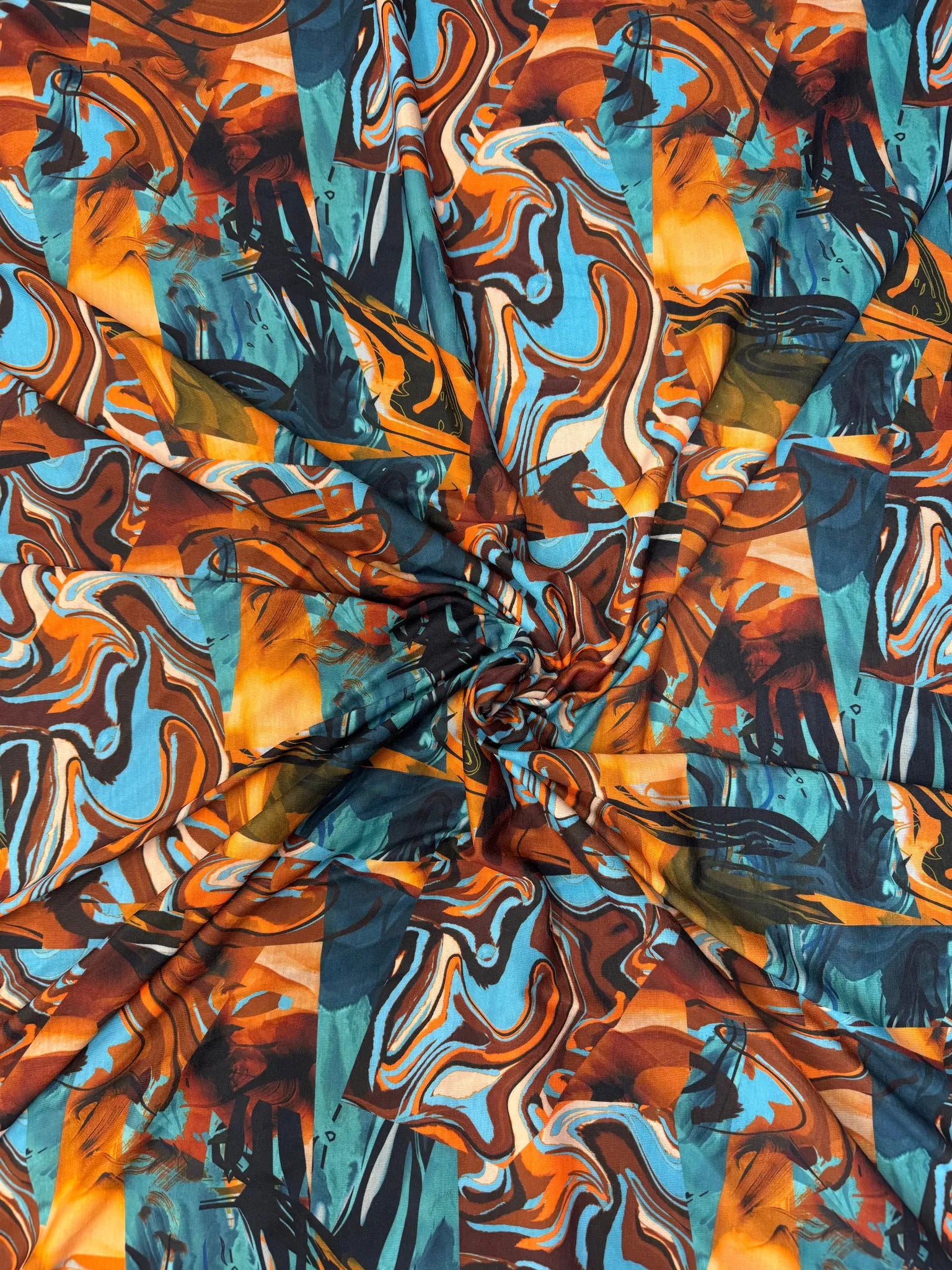 Abstract swirl print fabric in blue, orange, and brown.